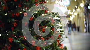 Red camera balls. New Year`s and abstract blurred shopping mall background with Christmas tree decorations.