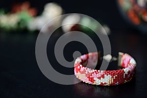 Red camouflage seed beads bracelet on a dark background