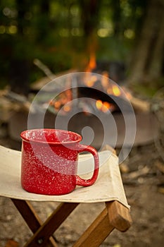 A red camping cup with a campfire