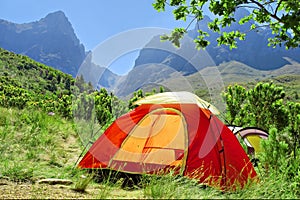 Red camping tent in misty mountains - springtime colors