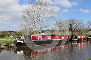 Red canal boats on Lancaster canal at Galgate