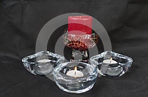 Red candle with 3 white candles in holders