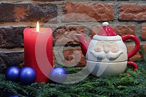 Red candle, blue christmas balls and Santa Claus teapot