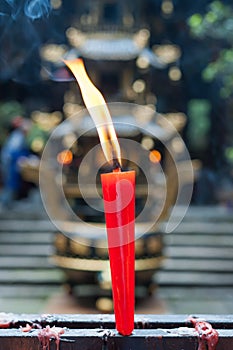 Red candle burning in a buddhist temple