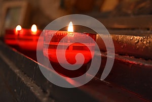Red candle burning in a church detail
