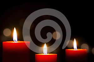 Red Candle with fire against defocused lights in darkness with golden bokeh in the dark Background