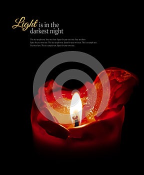 Red candle with flame and melting wax, black background, sample