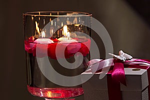 Red candle lights in a brown glassess and gift for Valentine day