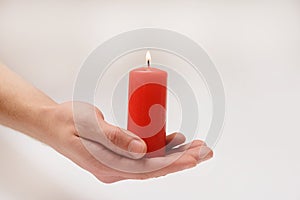 Red candle in loving hands