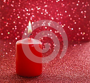 Red candle. Red glittering christmas lights.