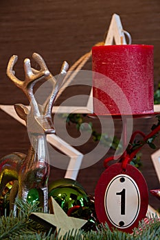 Red candle and traditional Christmas decoration for the first Advent.