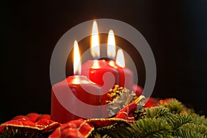 Red candles of an Advent wreath with fir branches