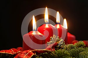 Red candles of an Advent wreath with fir branches