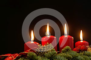 Red candles of an Advent wreath with fir branches