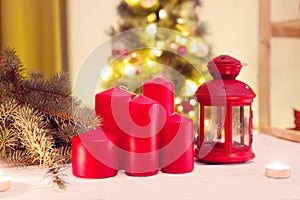 Red candles against christmas tree background in the interior