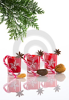 Red candles, candle holders with crystal snowflakes, sugar canes and anise stars, isolated on reflective white perspex background photo