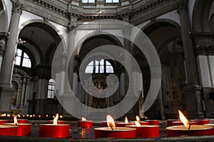 Red candles and church interior,venice, italy