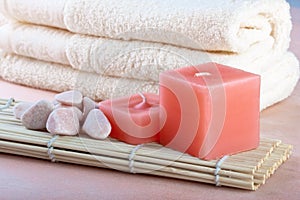 Red candles and towel with peach background