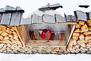 Red candles, wood logs and snow in Dolomity mountains, winter image