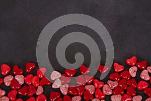 Red Candy hearts on a black chalkboard