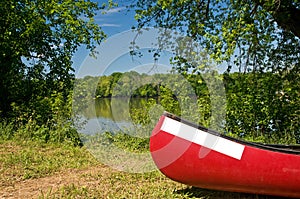 Red canoe on riverbank