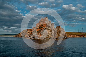 Red cape Shamanka rock in Lake Baikal, background clouds, sunset