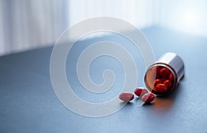 Red capsule pills and brown plastic drug bottle. Codeine and guaifenesin capsule pills to relieve coughing. Cough medicine.