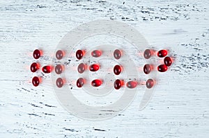 Red capsules with medicine or vitamins in liquid form lie on a white background. The word HELP. Ivf concept