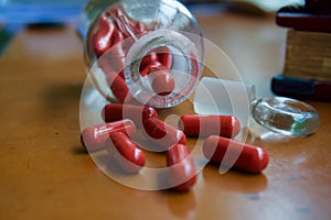Red capsules and pharmacy glass bottle
