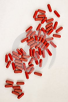 Red capsules pills heap on white background. Medicine pharmacy concept. Close up top view