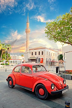 Red car on background of symbol of Bodrum mosque Merkez Adlie Jami
