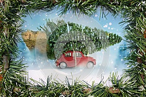 Red car carrying christmas tree with frame