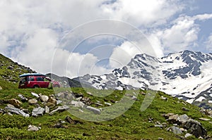 Red car climb the road in alps