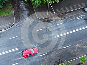 Red car crossing a flooded street after rain. aerial view