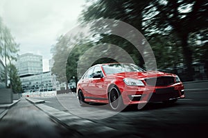 Red car drive on asphalt road in the city at daytime