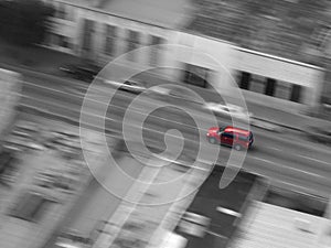 Red Car Driving Downtown in City Fast with Motion Blur