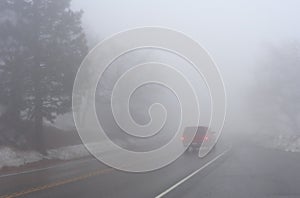 Red Car Driving in Thick Fog