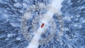 Red car driving on winter road. Aerial view.