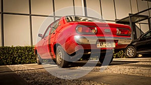 Red car in front of modern building