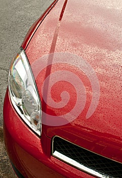 Red car headlight with rain drops