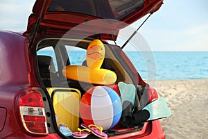 Red car with luggage on beach. Summer vacation trip