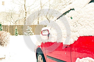 Red car and mirror snow capped. Winter-time outside. Outdoors.