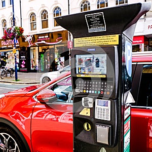 Red Car Parked Next To A Modern Parking Meter