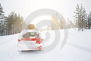 Red car with roof box on winter snow road..Snow winter forest with car on the road