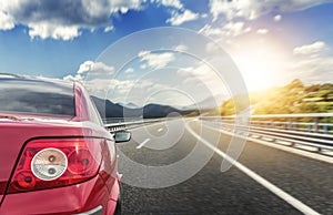 Red car rushing along a high-speed highway.