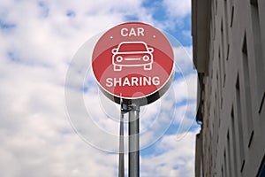 Red car sharing sign post in the city, urban mobility concept. Modern transportation service