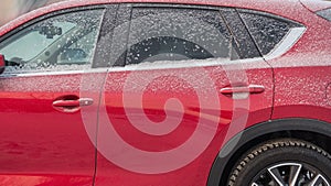 Red car after snowfall, bad weather for driving.Winter season