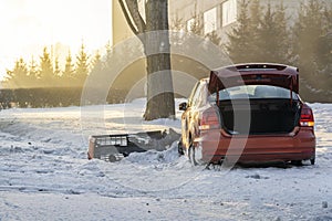 The red car was involved in an accident on a winter highway and flew off the road to the side of the road. Dangerous