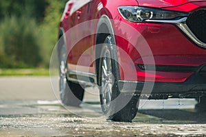 Red car with white soap on the body in car care shop.  on  background.