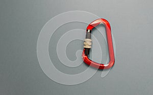 Red carabiner with clutch on a grey background
